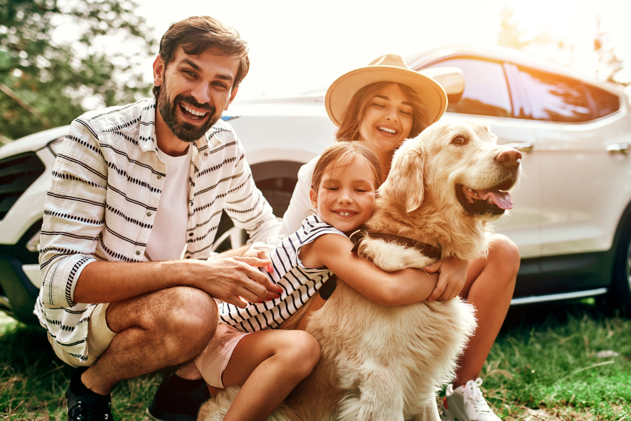 Familia posa para una foto con su mascota antes de viajar de vacaciones.